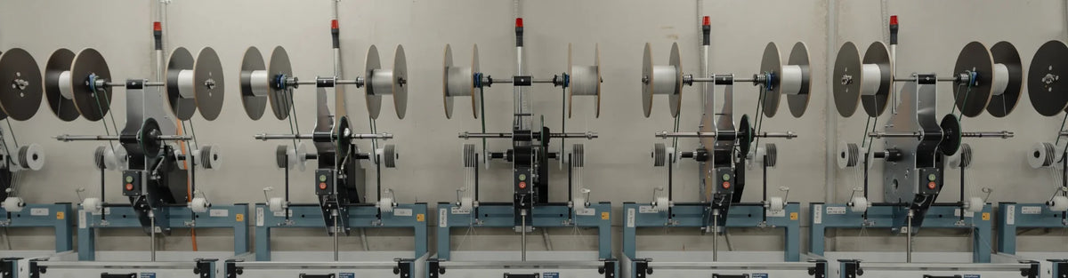 Long row of braiding machines down the length of the Tasline factory floor