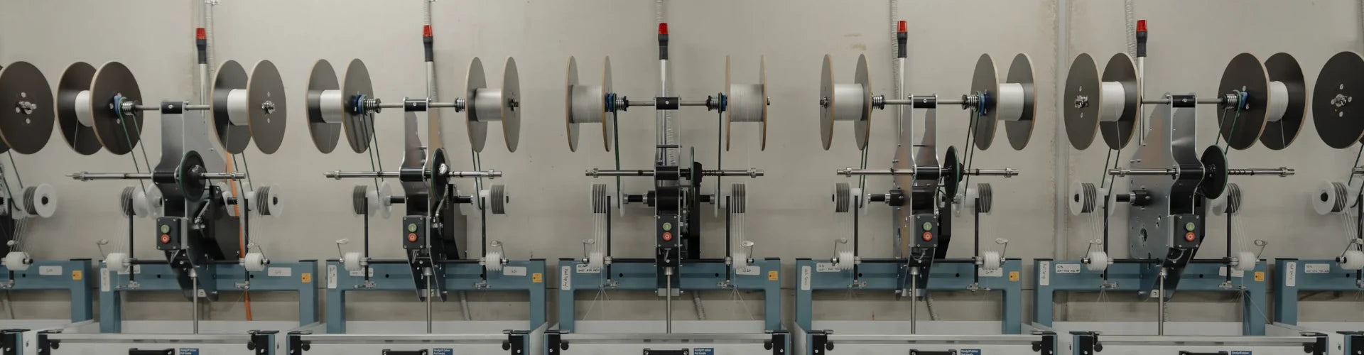 Long row of braiding machines down the length of the Tasline factory floor