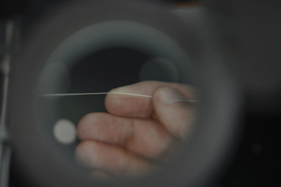 Hand holding a single strand of Tasline braid up to the light for inspection